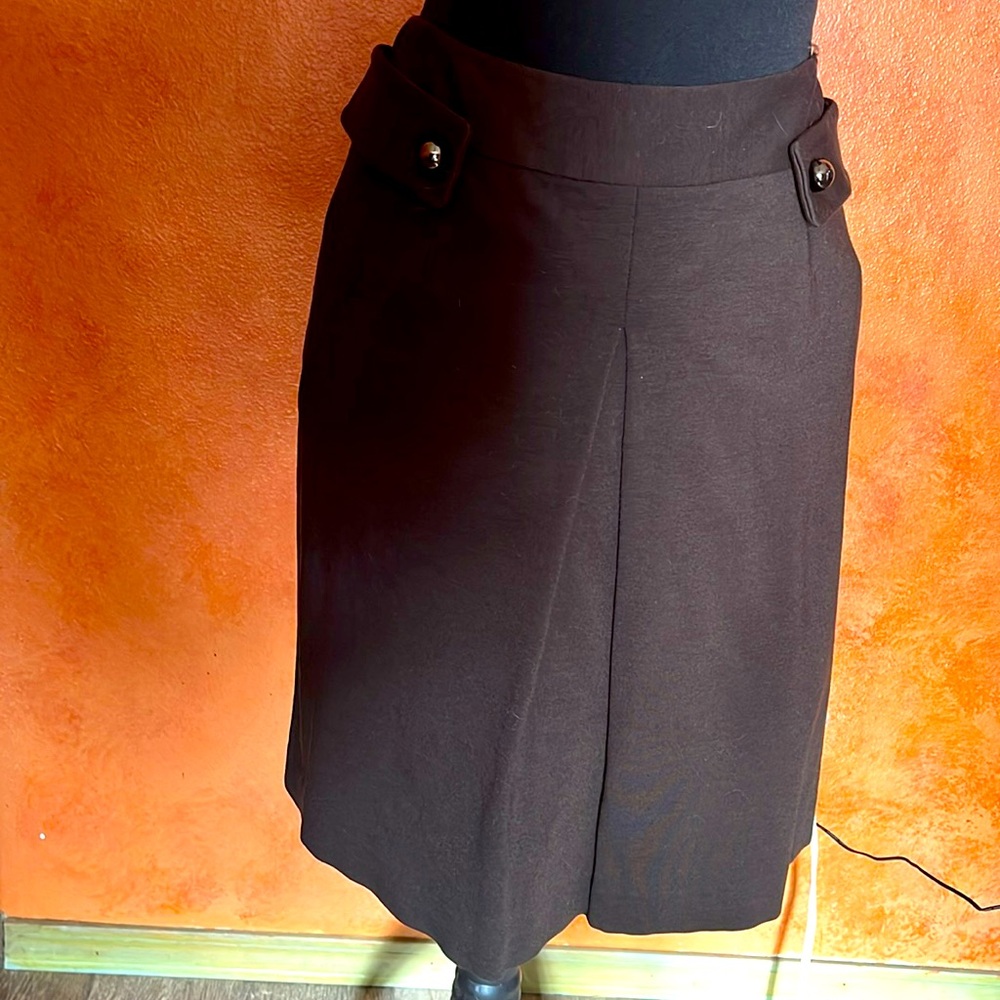 Mod style knit skirt w front pleat and buttoned tabs.